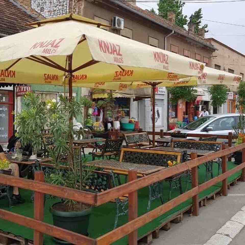 Letnja bašta sa stolovima i suncobranima