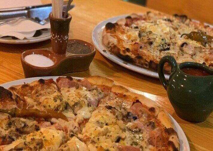 Pizza na stolu sa slanikom i kečapom